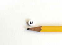 Letter U Plastic Alphabet Beads, White With Black Initial, 7mm x 3.5mm - 100 pieces (BTU)